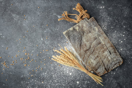 Baking recipe background, sprinkled wheat flour, grain and ears on wooden board. Cooking dough, banner, menu, recipe place for text, top view,の写真素材
