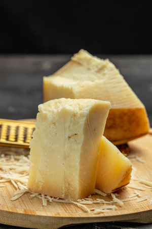 gruyere hard yellow cheese. a traditional Swiss hard yellow cheese without holes, with a dark crust and a pleasant floral and nutty aroma, place for text, top view.の写真素材