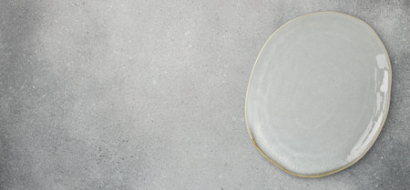 large flat plate with uneven edges on a gray background, banner formatの写真素材