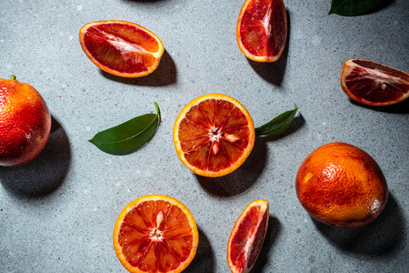 Bloody Sicilian oranges on a gray background, whole and cut sliced, halved with leaves, pattern. top view.の写真素材