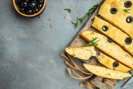 homemade focaccia bread baking with seasonings on a wooden board. banner, menu, recipe place for...