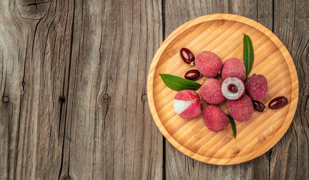 Fresh ripe lychee fruit and peeled lychee on a wooden background. banner, menu, recipe place for text, top view.の写真素材