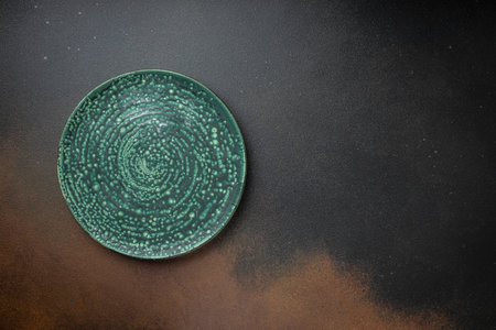 Empty ceramic green plate with granite texture on a dark background. place for text, top view.の写真素材
