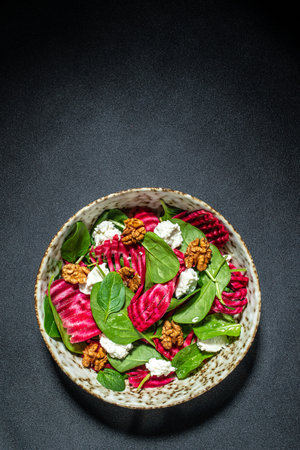 Vegetable salad of beet, baby spinach, nuts and cheese. vertical image. top view. place for text.の写真素材