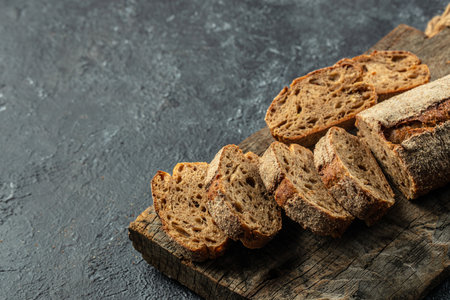 traditional sourdough baguette bread cut into slices on a wooden board. banner, menu, recipe place...
