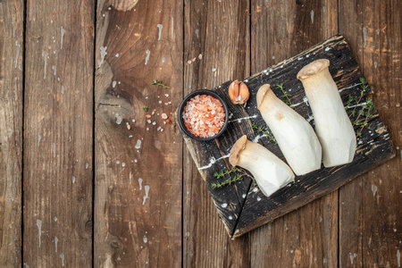 King oyster mushroom Pleurotus eryngii on a wooden background, banner, menu, recipe place for text, top view,の写真素材