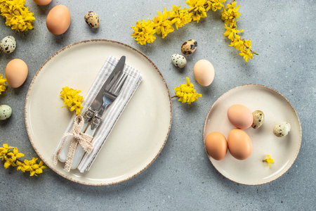 Festive Easter table setting with eggs and flowers on light background. Happy Easter card design,...