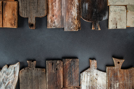 Set of wooden chopping cutting boards on a dark background. Handmade Charcuterie style serving boards. manual work. place for text, top view.の写真素材