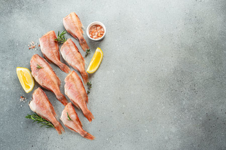 fish, red snapper with lemon, rosemary, salt on a light background. Healthy food concept. place for...