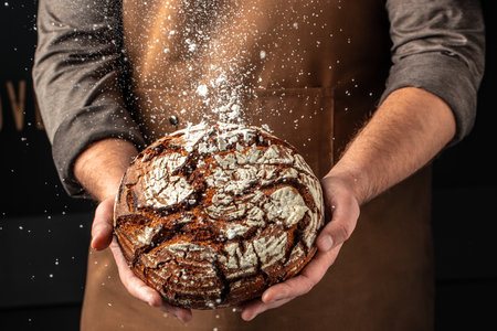 male hands holding bread. domestic cozy bakery pastry. Healthy food concept. place for text.の写真素材