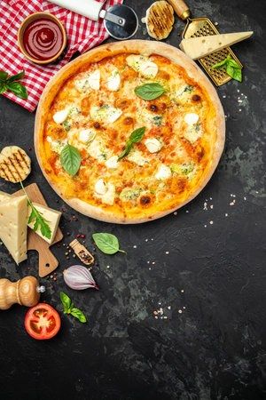 four cheese pizza, homemade italian pizza. Pizza on rustic black background. traditional italian food. place for text, top view.の写真素材