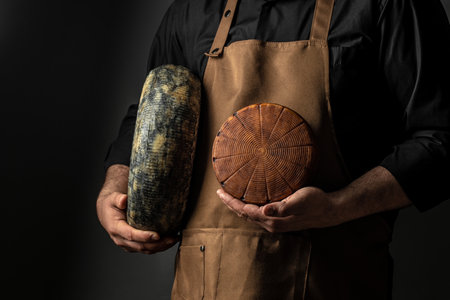 cheesemaker mele hands holding wheel hard cheese,の写真素材