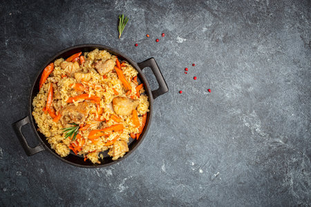 Uzbek pilaf in cast-iron pan. banner, menu, recipe place for text, top view.の写真素材