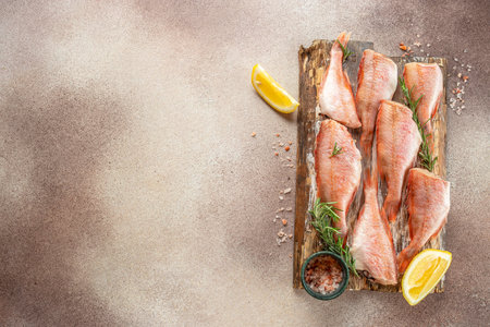 fish, red snapper with lemon, rosemary, salt on a light background. Healthy food concept. place for...
