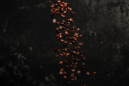 Roasted coffee beans falling on black background, Concept for coffee product advertising, Selective focus, place for text.の写真素材