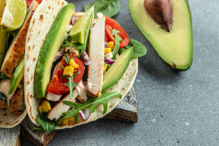 Tacos with grilled chicken, avocado, fresh tomatoes, limes. mexican burritos on a wooden board. banner, menu, recipe place for text, top view.の写真素材