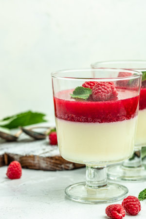 Raspberry sorbet with whipped cream and mint. Italian dessert on a light background in small jars. vertical image. top view. place for text.の写真素材
