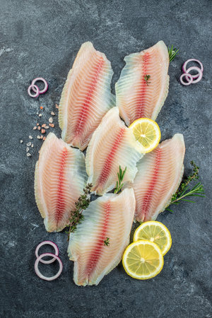 Fresh fish tilapia fillet. Detox and healthy superfoods concept. vertical image. top view. place for...