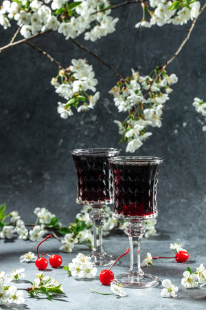 Cherry liqueur in a glass and fresh fruit with fresh berries and blossoms, Berry alcoholic drinks concept.の写真素材