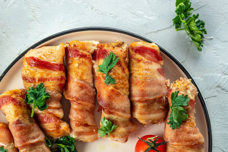 Delicious chicken rolls wrapped in strips of bacon on a cast-iron frying pan. Concept healthy and balanced eating. place for text, top view.の写真素材