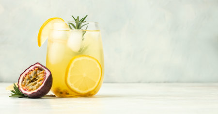 glass of Iced passion fruit soda with lemon and passion fruit half slice on a light background,...