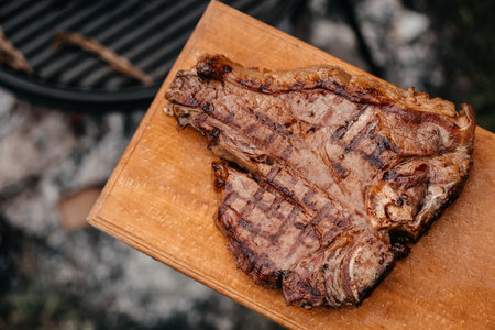 Dry Aged Barbecue Porterhouse Steak T-bone beef steak sliced with large fillet piece with herbs and...