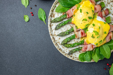 poached eggs benedict with green asparagus wrapped in grilled bacon, Ketogenic diet. Low carb high fat breakfast. Healthy food concept. place for text, top view.の写真素材