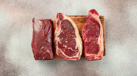 Variety of fresh Black Angus Prime raw beef steaks on a light background. banner, menu, recipe place...