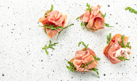 Delicious crostini with cheese cream and prosciutto on a light background. Long banner format. top view.の写真素材