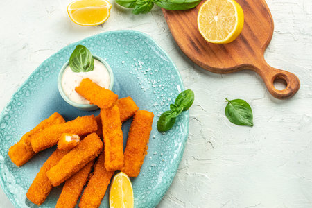 Golden roast Fish Sticks Fingers with sauce. Food recipe background. Close up.
