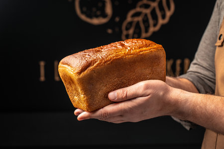 Wheat square bread in hands, domestic cozy bakery pastry. Healthy food concept. place for text,