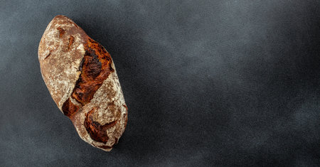freshly baked bread on a dark background, organic healthy products. clean diet concept. Long banner...