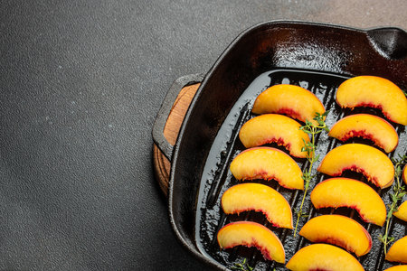 Ripe grilled peaches with honey on aa grill pan on a dark background. top view.の写真素材