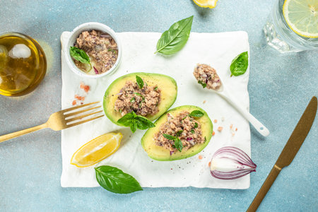 Delicious avocado stuffed with tuna salad on a light background. balanced food concept. top view.の写真素材