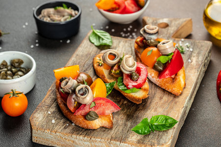 Toast tapas with anchovies, tomato on bread. Traditional Italian appetizer or snack, antipasto.の写真素材