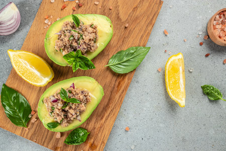 Tuna stuffed avocado on a wooden board. Concept healthy and balanced eating. place for text, top view.の写真素材