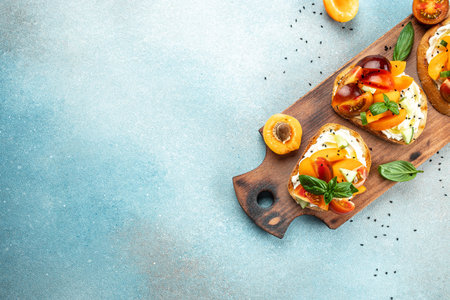 Healthy vegetarian fruit sandwich with cream cheese, peaches, tomatoes and green basil leaves. clean diet concept. place for text, top view.の写真素材