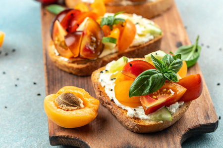 Gourmet sandwiches bread toast, bruschetta with cream cheese, peaches, tomatoes and green basil...