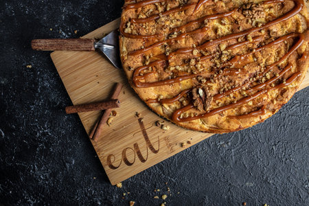French apple tart with caramel on a dark background. top view. copy space for text.