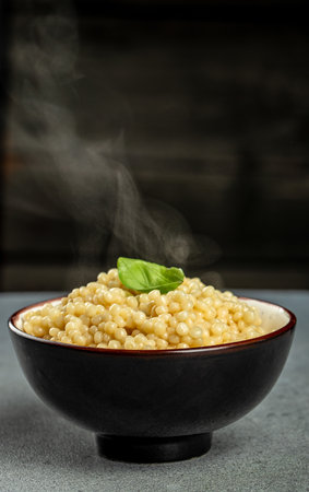 cooked ptitim pasta in a bowl with hot steam, vertical image. copy space for text,の写真素材