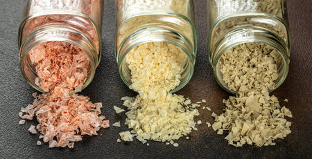 collection of different types of salt on a dark background. Long banner format. top view. copy space...