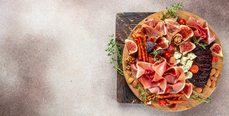 fruit, cheese and meat variety board. prosciutto, ham snack slices with figs and cheese on a light...