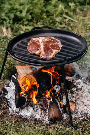 meat steak. Fresh raw Prime Black Angus beef steak cooking on flaming grill with smoke,の写真素材