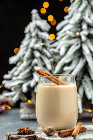 Homemade eggnog with cinnamon in glass on wooden board. Typical Christmas dessert. vertical image. top view. copy space for text,の写真素材