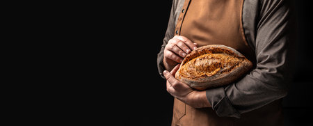 baker holds homemade bread. Long banner format. copy space for text.