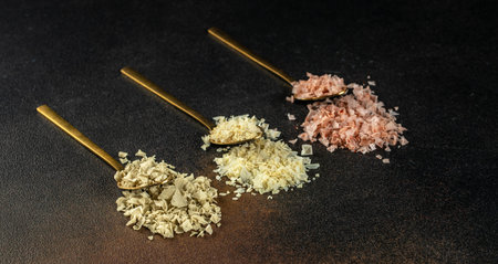 collection of different types of salt on a dark background. Long banner format. top view. copy space...