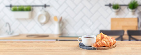 Croissant and coffee on wooden table top in modern kitchen, breakfast concept, Long banner format. copy space for text,の写真素材