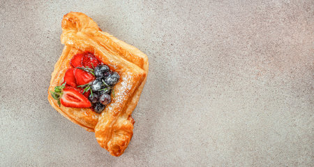 Small open pie made of puff pastry with fresh berries on a light background. Long banner format. top view,の写真素材