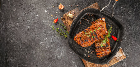 Grilled fresh lamb ribs with thyme, garlic and chili in pan. Long banner format. top view. copy space for text.の写真素材
