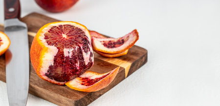 Cleared of peel Red blood orange on a wooden board, cooking dish. Long banner format. top view. copy space for text.の写真素材